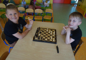 Dwóch chłopców gra w szachy.